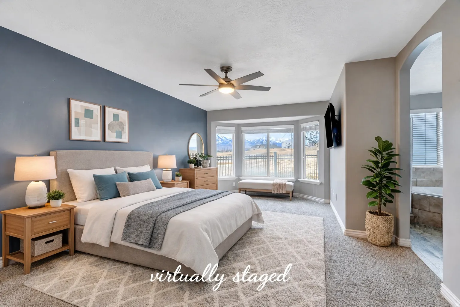 Bedroom featuring light colored carpet, arched walkways, a ceiling fan, and connected bathroom
