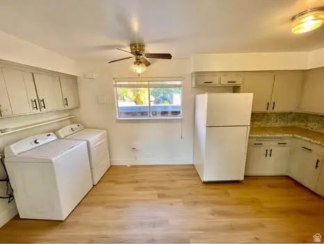 Laundry area featuring light wood-style floors, ceiling fan, and washing machine and clothes dryer