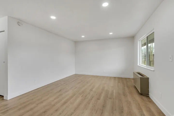 Family room with light wood-style floors and recessed lighting