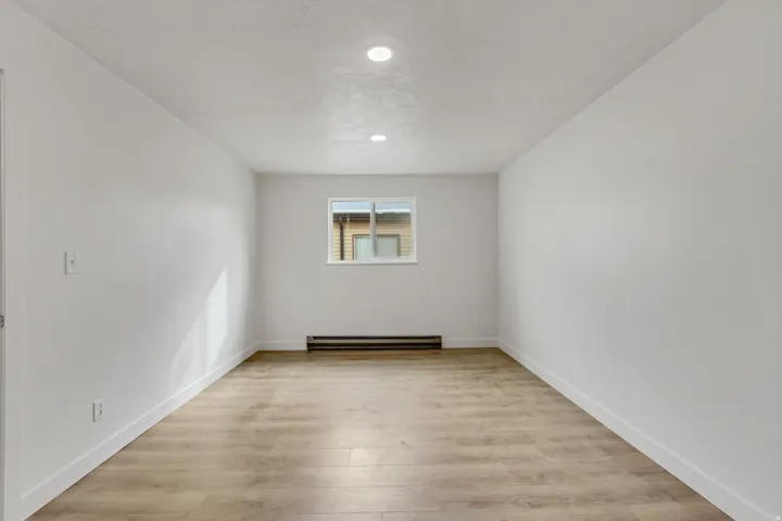 Spare room featuring light wood-style flooring and a baseboard heating unit