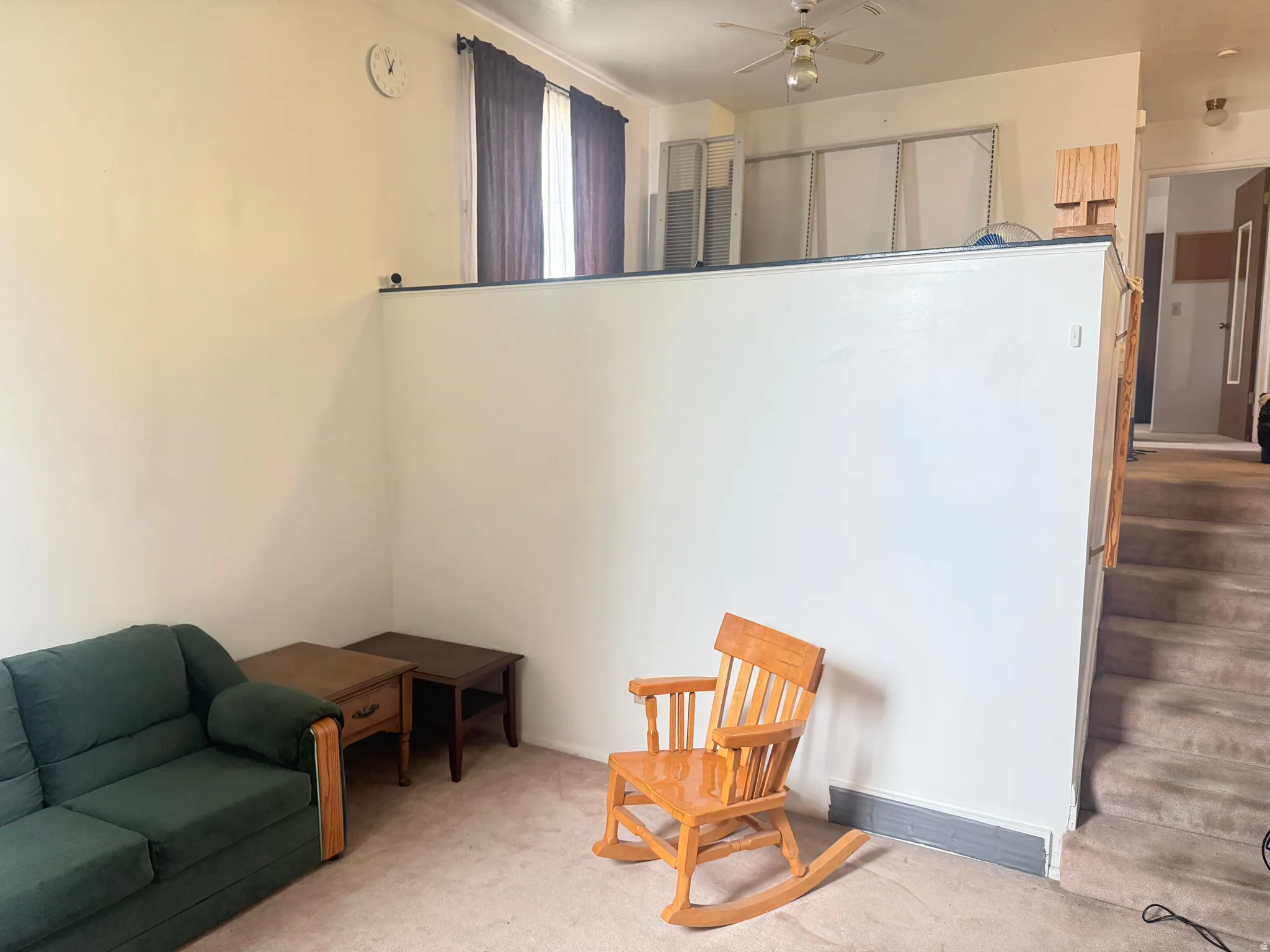 Living area with carpet floors and a ceiling fan