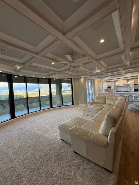 Living area with coffered ceiling, recessed lighting, and ceiling fan