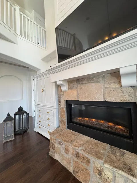 Detailed view of a stone fireplace and wood finished floors