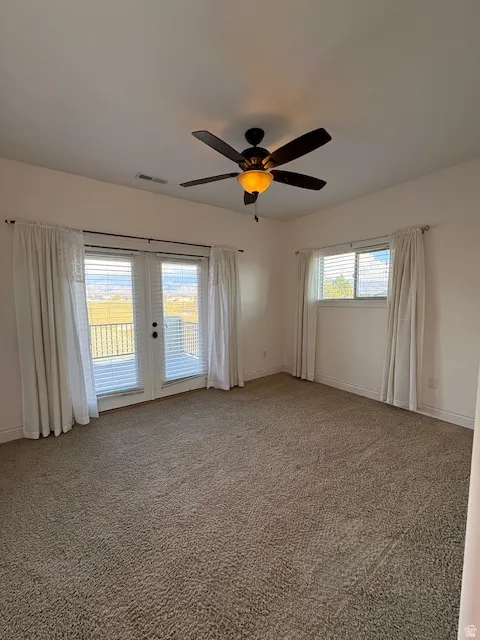 Unfurnished room with french doors, light colored carpet, and a ceiling fan