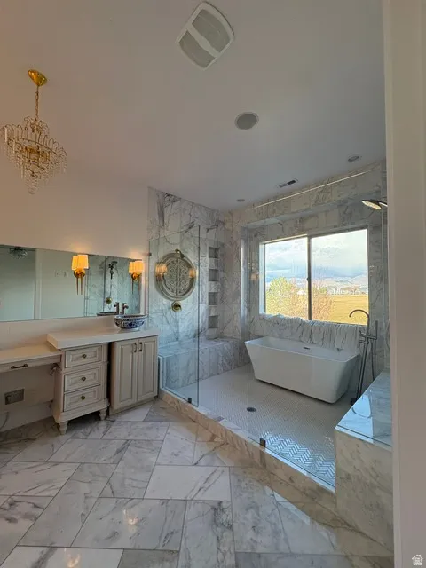 Bathroom featuring a marble finish shower, a soaking tub, vanity, and light marble finish floors