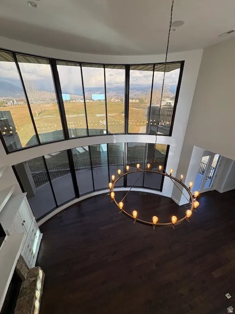 Living area with a fireplace, a high ceiling, and wood finished floors