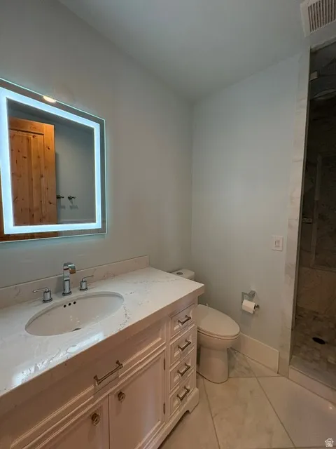 Bathroom with vanity and tiled shower