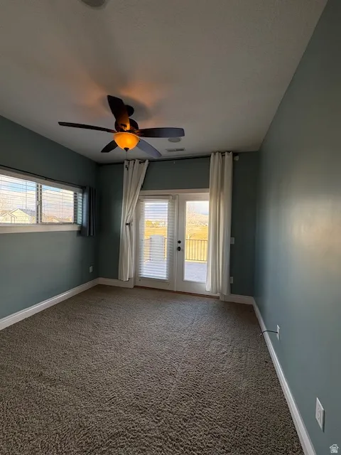 Empty room featuring carpet floors and ceiling fan