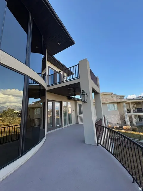 Rear view of house with stucco siding, a patio area, and a balcony