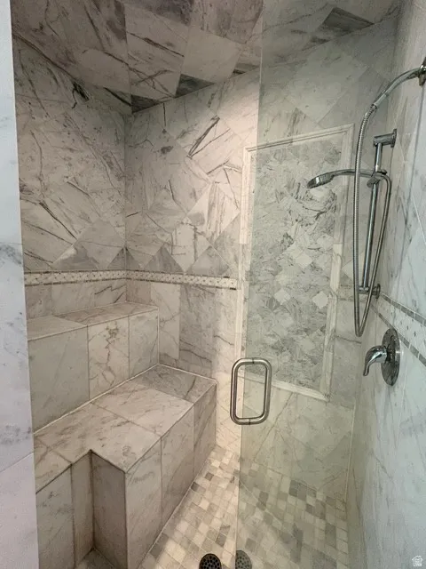 Full bath featuring a marble finish shower