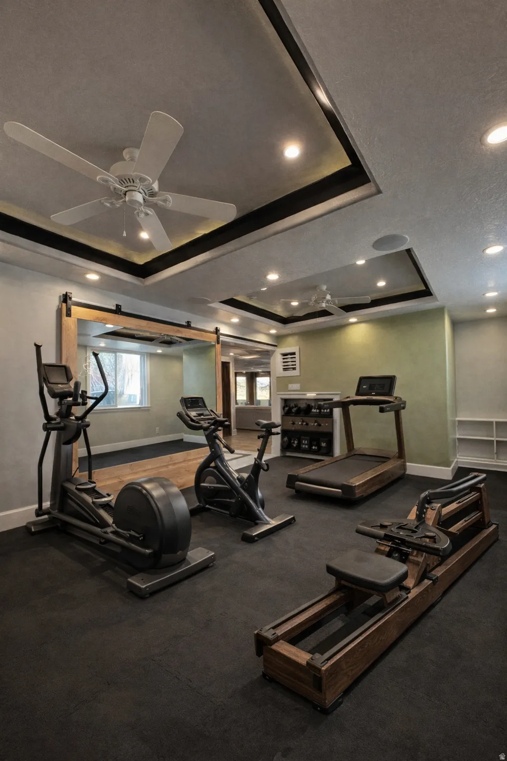Exercise room featuring a tray ceiling, recessed lighting, and a ceiling fan