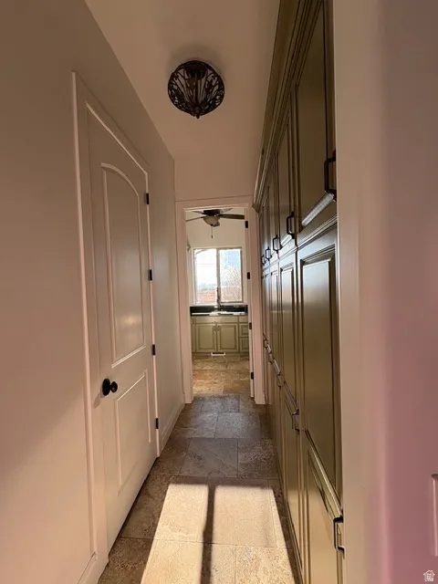 Hallway with stone tile flooring and baseboards