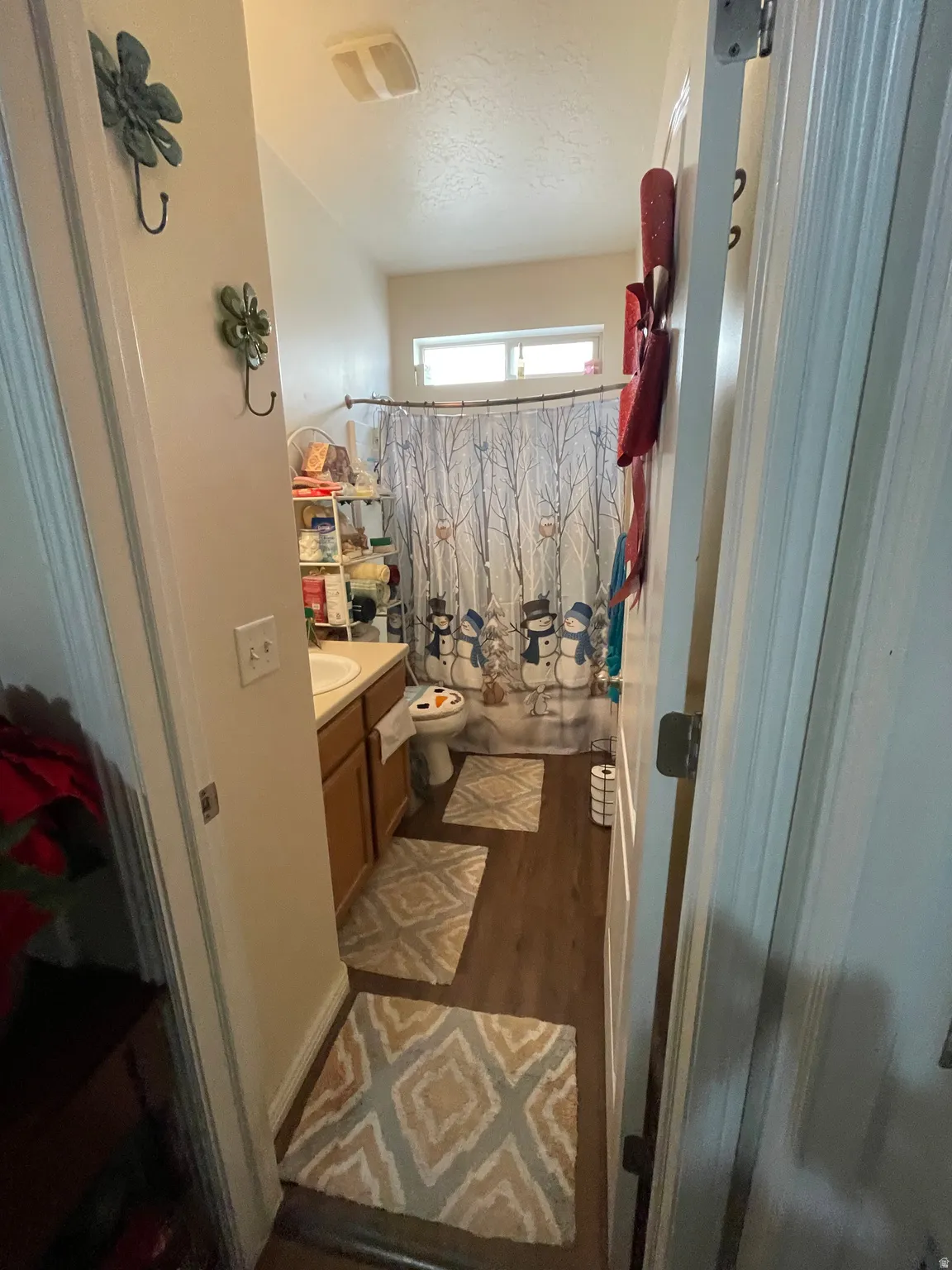 Bathroom with vanity, dark wood-style flooring, and shower / bath combination with curtain