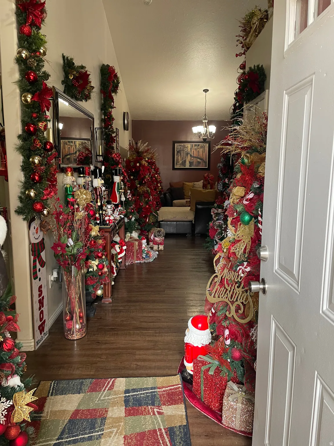 Entryway featuring dark wood-style floors, a chandelier, and lofted ceiling