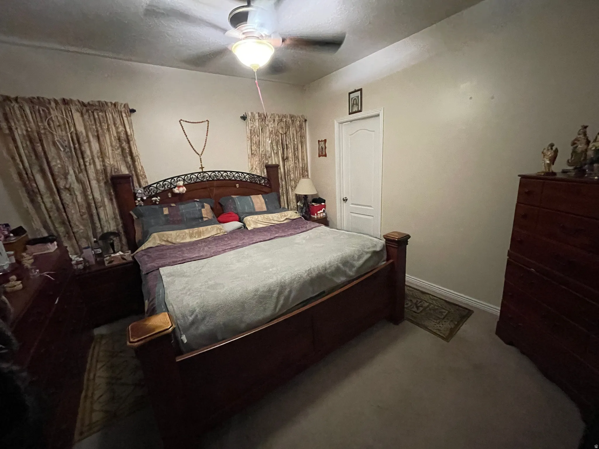 Carpeted bedroom featuring ceiling fan and baseboards