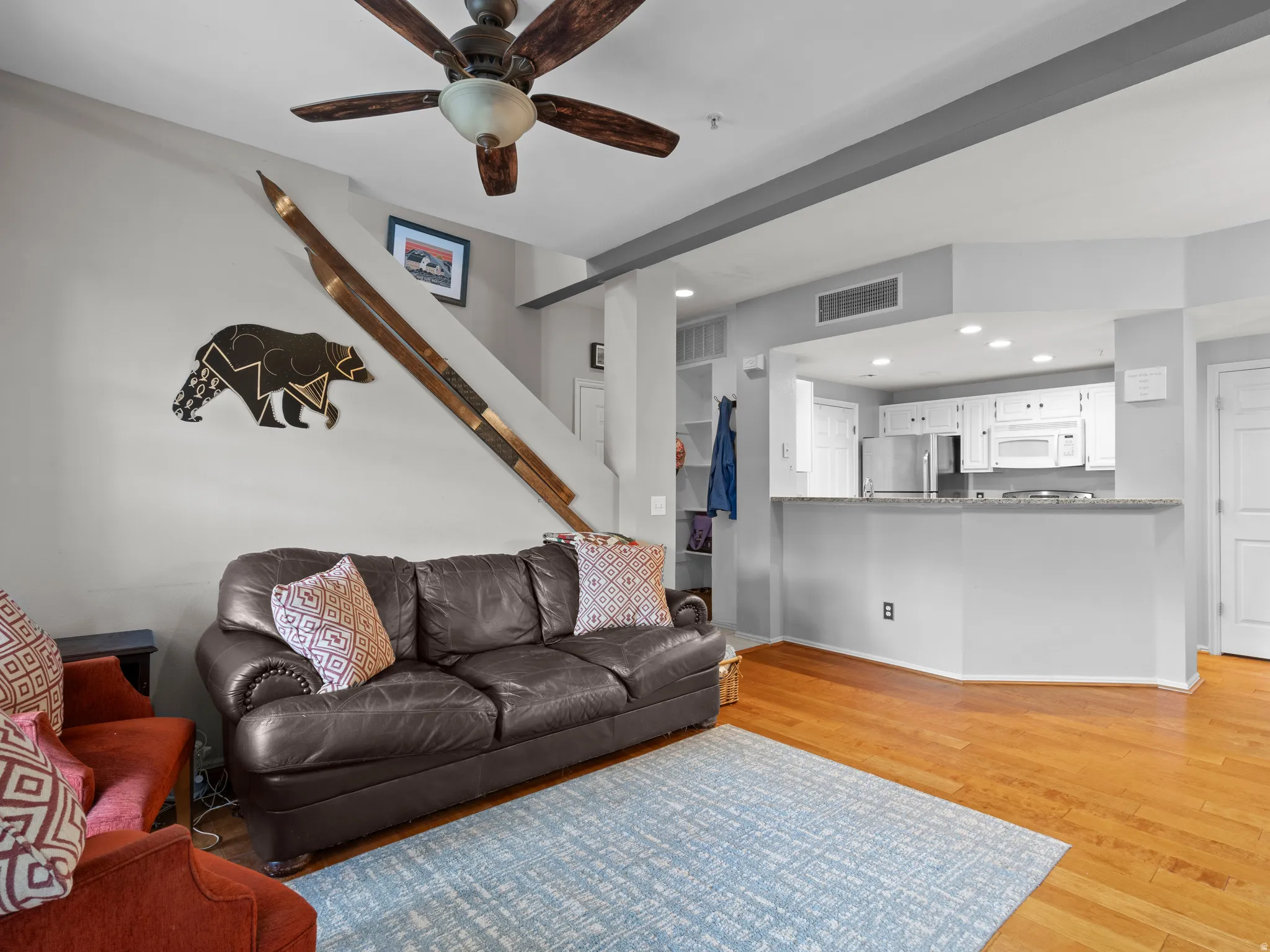 Living room featuring light wood-type flooring, a ceiling fan, and recessed lighting