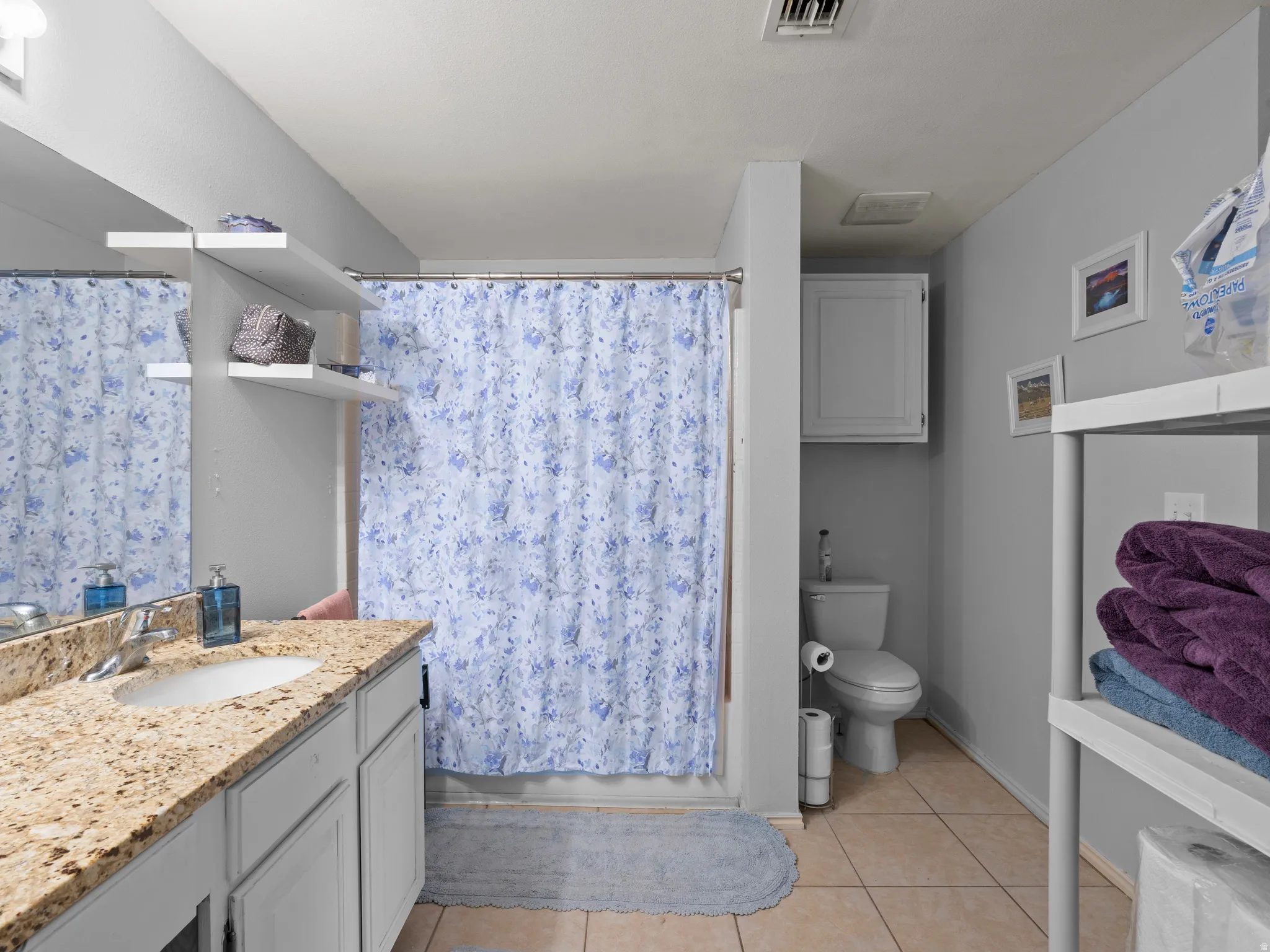 Bathroom featuring vanity, a shower with curtain, and light tile patterned floors