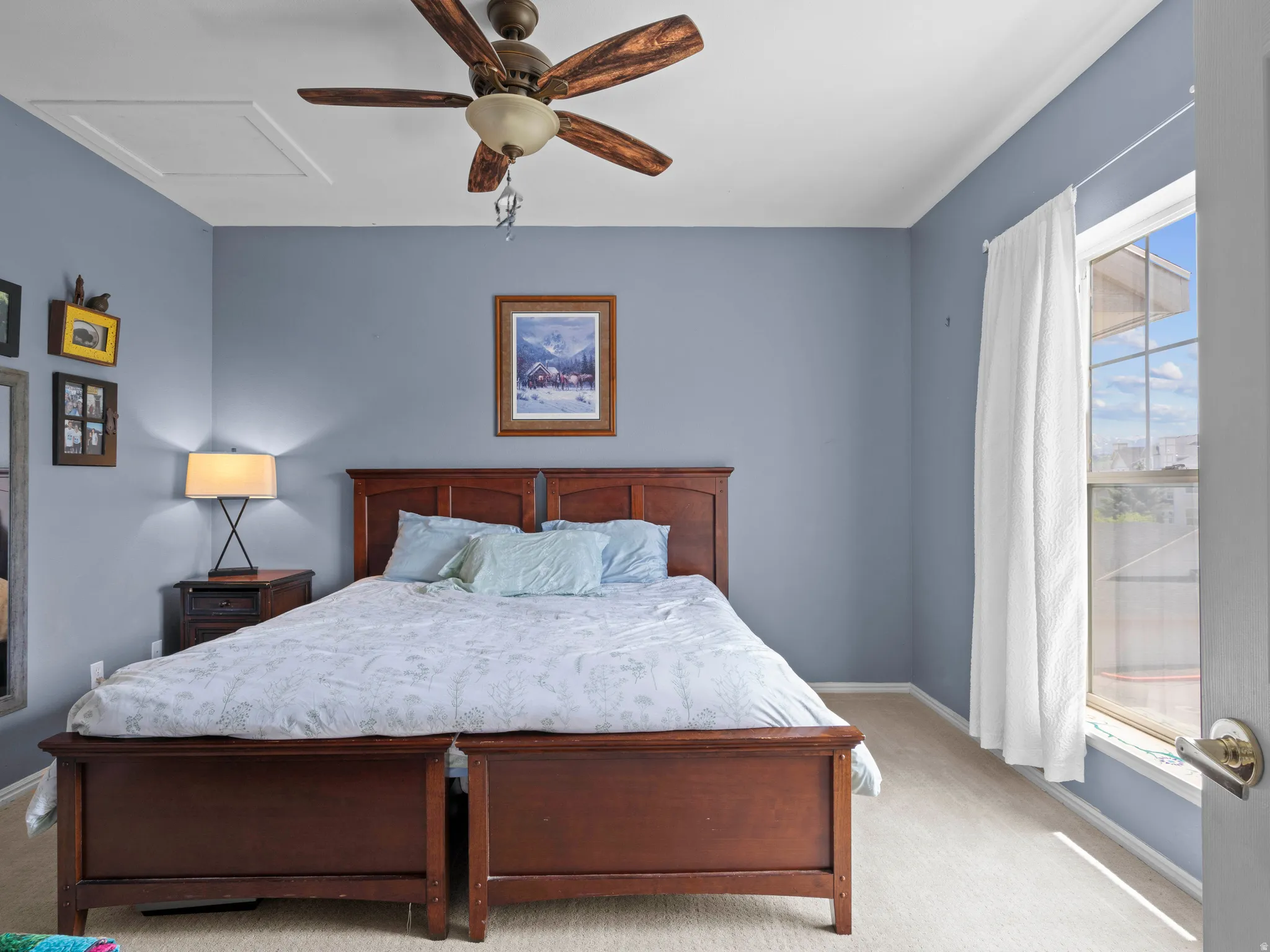 Carpeted bedroom featuring attic access and ceiling fan