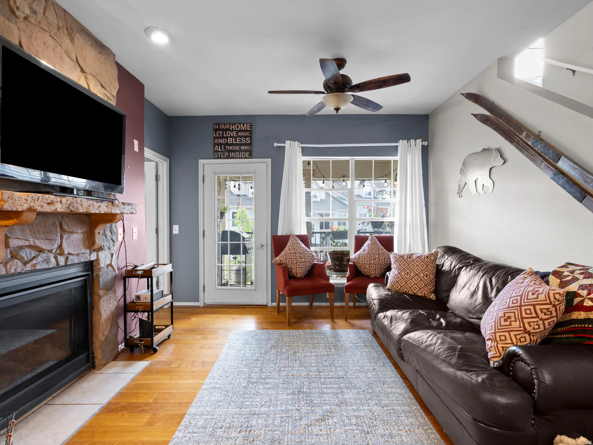 Living area featuring light wood-type flooring, a ceiling fan, and a fireplace