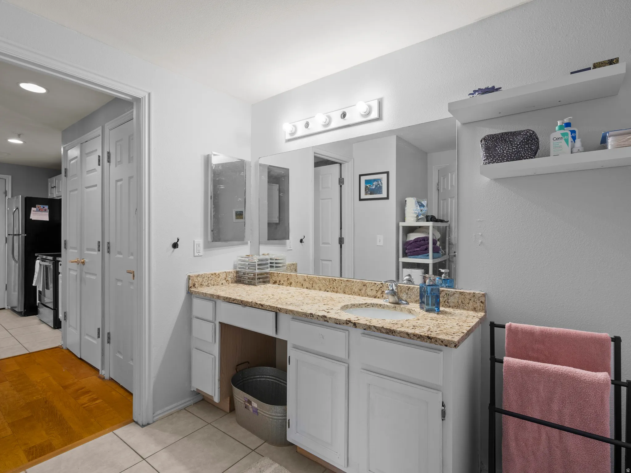Bathroom featuring light tile patterned floors, vanity, and a closet