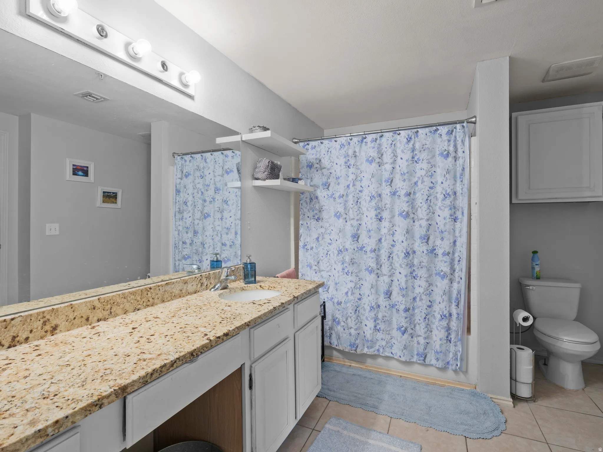 Bathroom featuring vanity, light tile patterned floors, and shower / tub combo