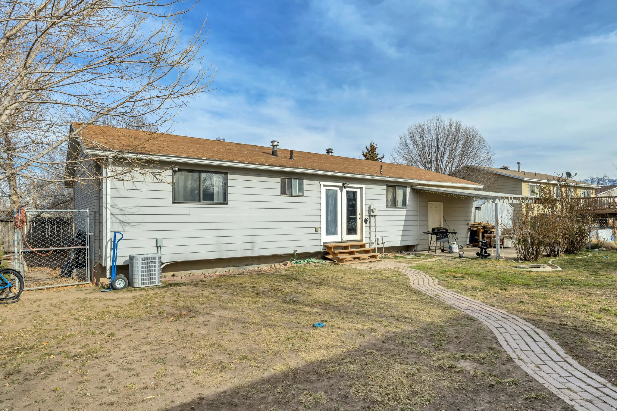 Back of property featuring entry steps, a gate, and a patio area