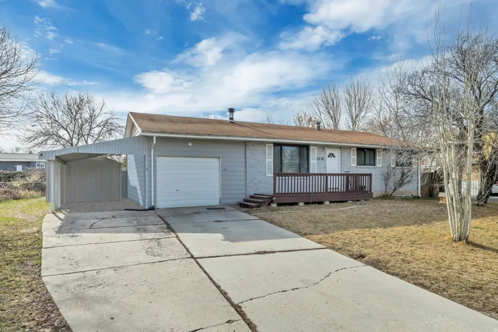 Ranch-style house with concrete driveway, an attached garage, brick siding, and a front yard