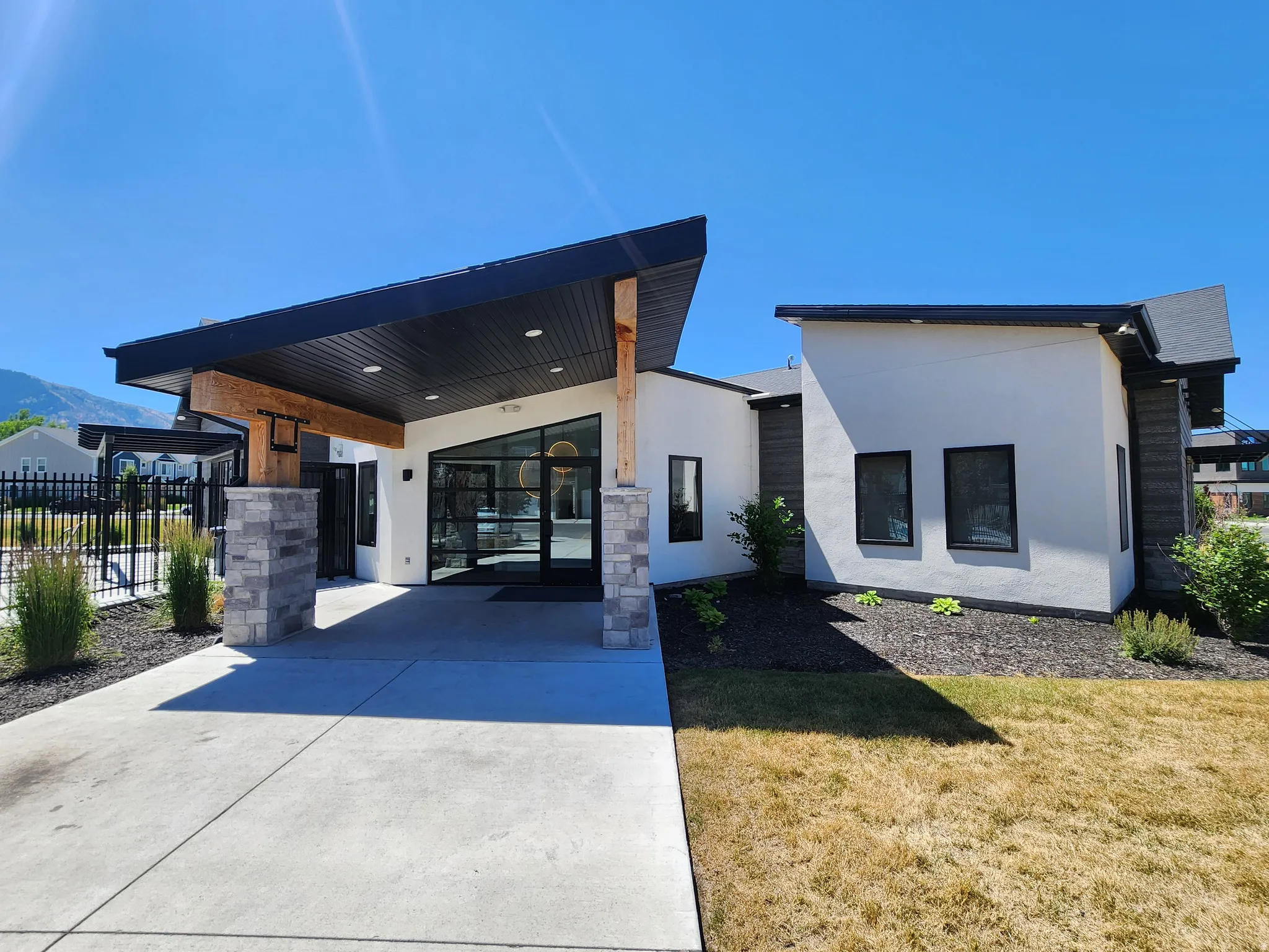 View of front of home with stucco siding, a patio area, and concrete driveway