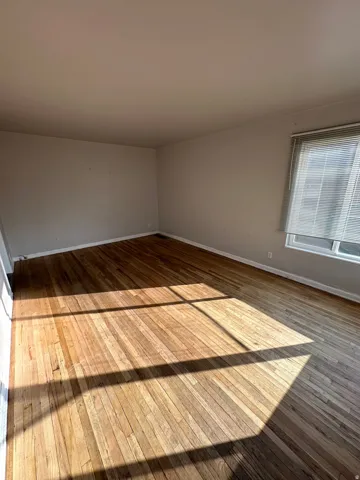 Unfurnished room with baseboards and hardwood / wood-style floors