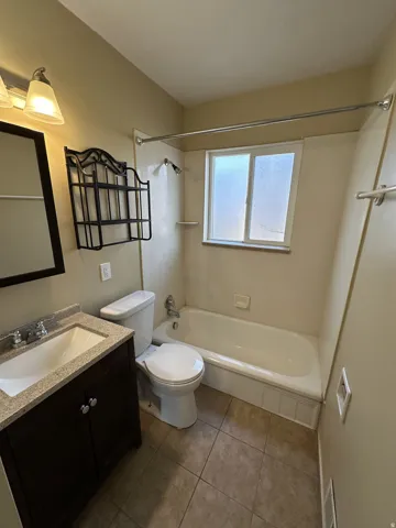 Bathroom with vanity, shower / washtub combination, and light tile patterned floors