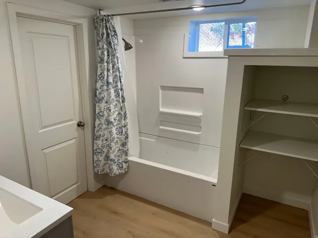 Full bath featuring light wood-type flooring, vanity, shower / tub combo, and a closet