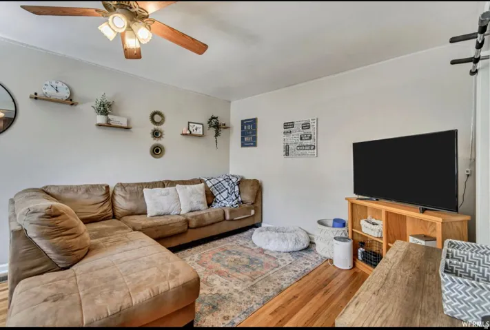 Living room featuring ceiling fan and wood finished floors