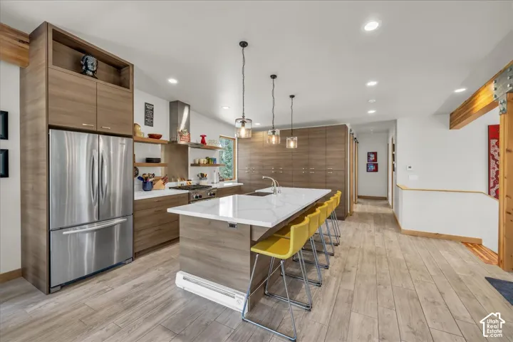 Kitchen with open shelves, stainless steel appliances, large island, and modern cabinets