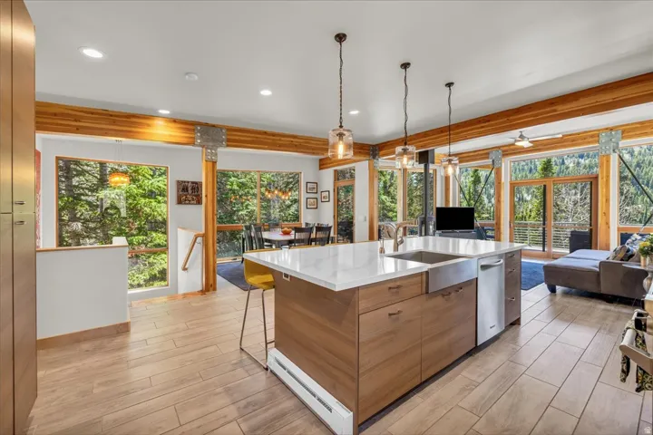Large kitchen island with sold surface counters centered in the middle of the great room surrounded by floor to ceiling windows