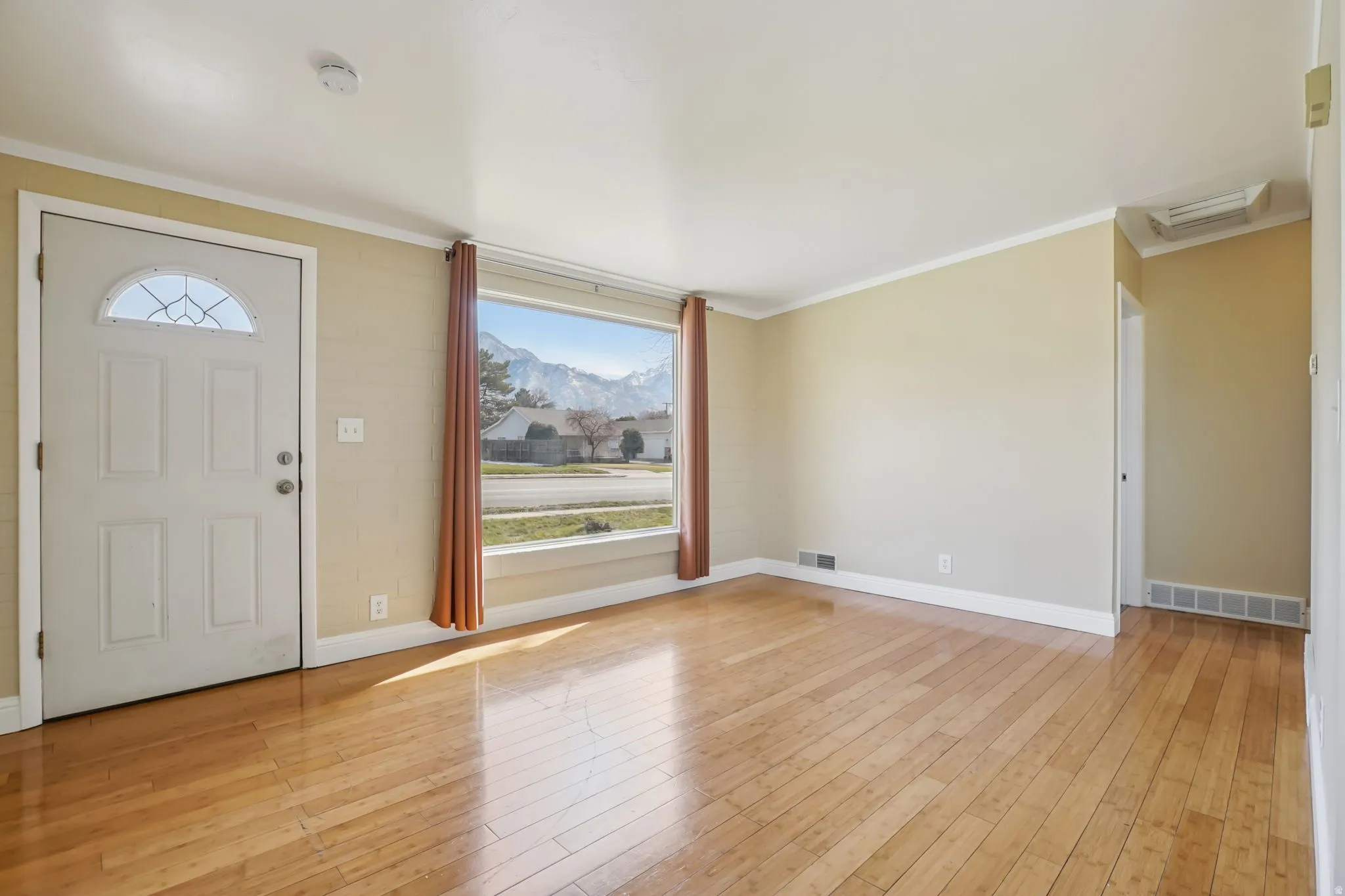 Entrance foyer with a mountain view, hardwood floors, and crown molding - north unit