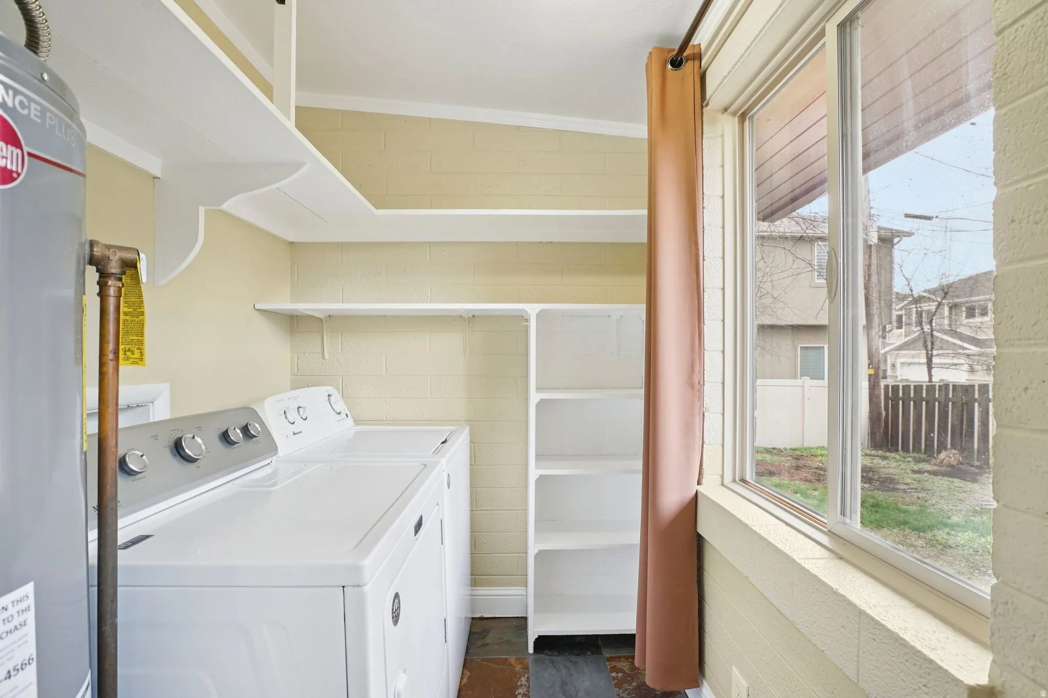 Laundry room with water heater, and washing machine and dryer