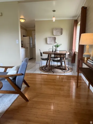 Dining space with ornamental molding and light wood finished floors