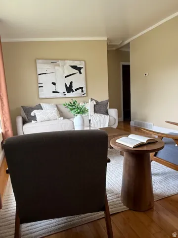 Living area featuring hardwood / wood-style flooring and ornamental molding