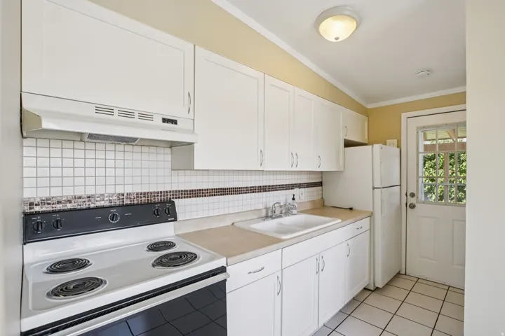 Kitchen featuring white appliances and white cabinets - north unit