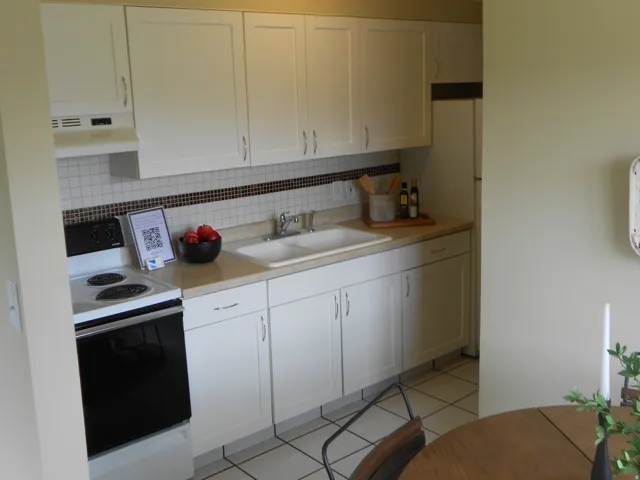 Kitchen featuring range with electric stovetop, white cabinets, light countertops, and light tile patterned flooring