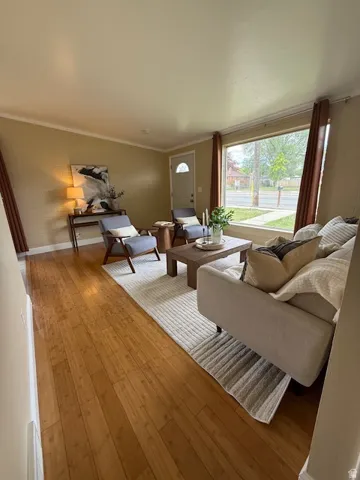 Living room with light wood-style floors and ornamental molding