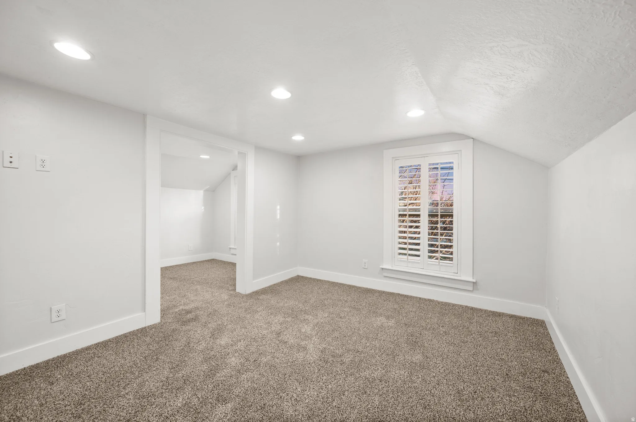 Additional living space featuring carpet, vaulted ceiling, and recessed lighting