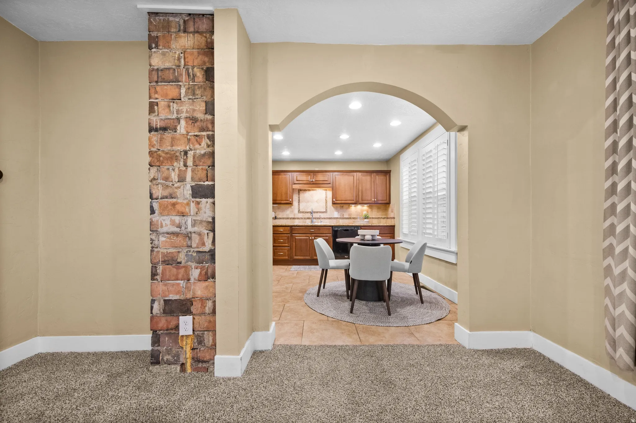 Dining space featuring arched walkways, light tile patterned floors, recessed lighting, and light colored carpet