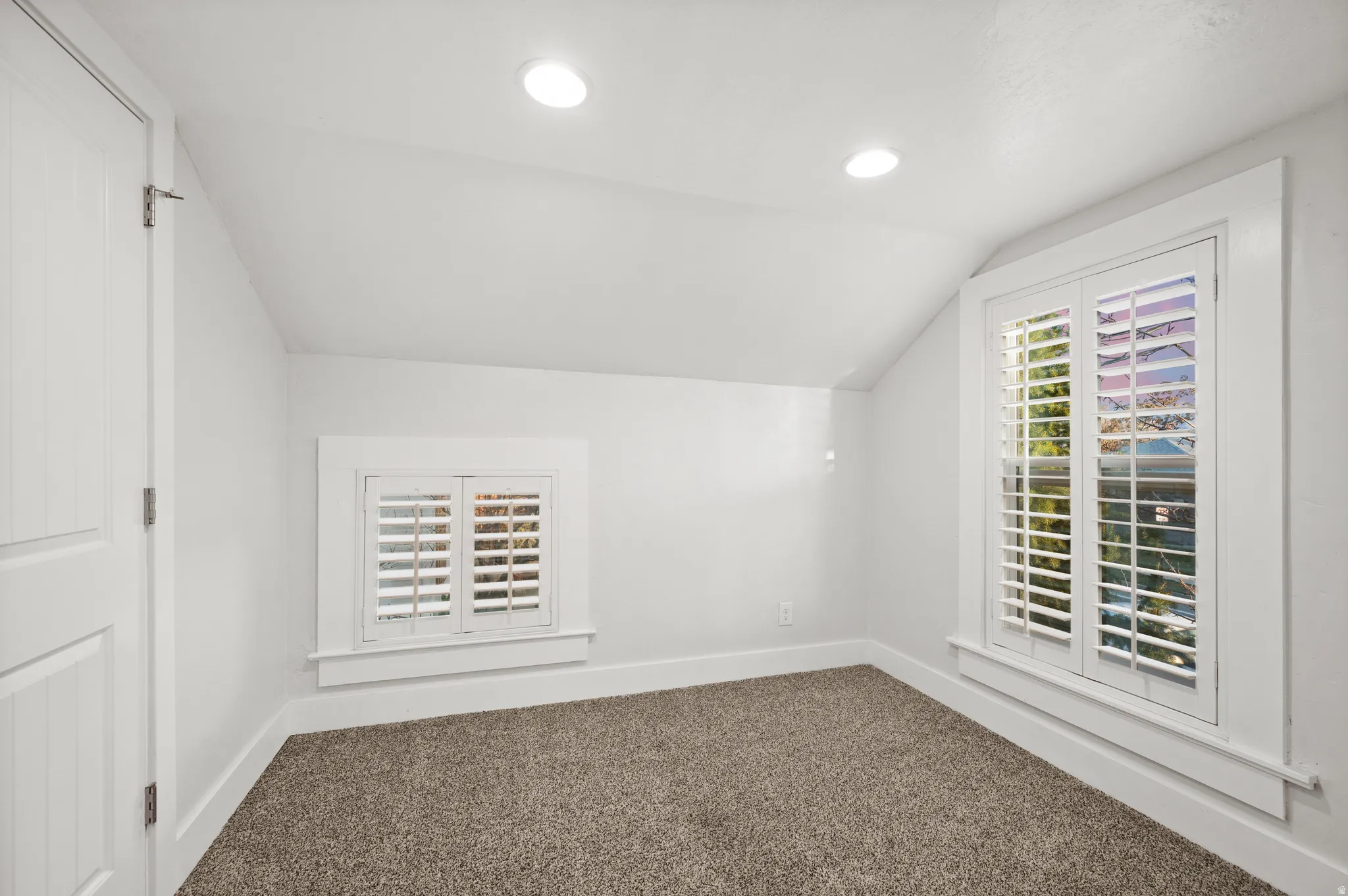 Bonus room with vaulted ceiling, dark carpet, and recessed lighting