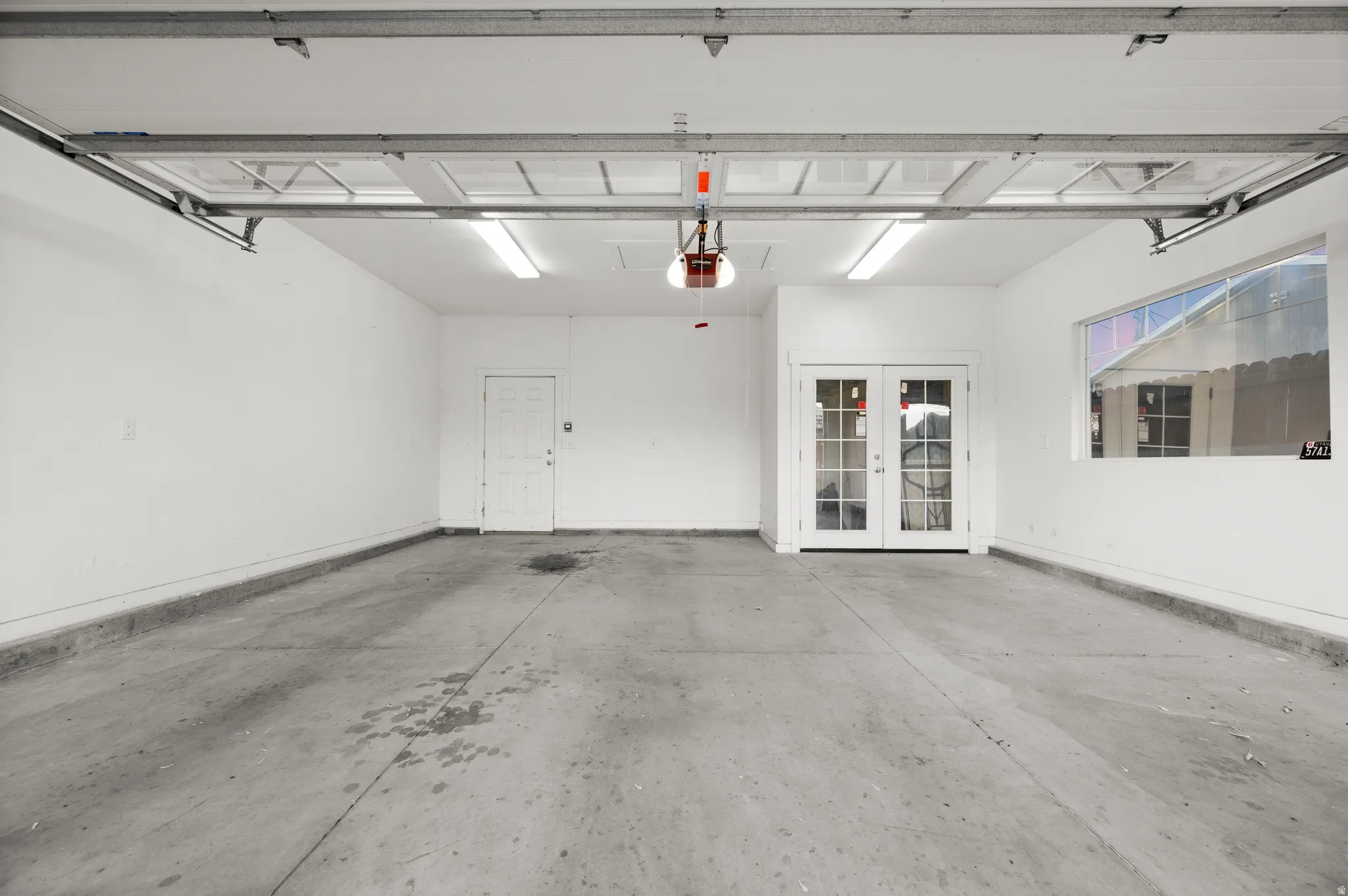 Garage featuring french doors and baseboards