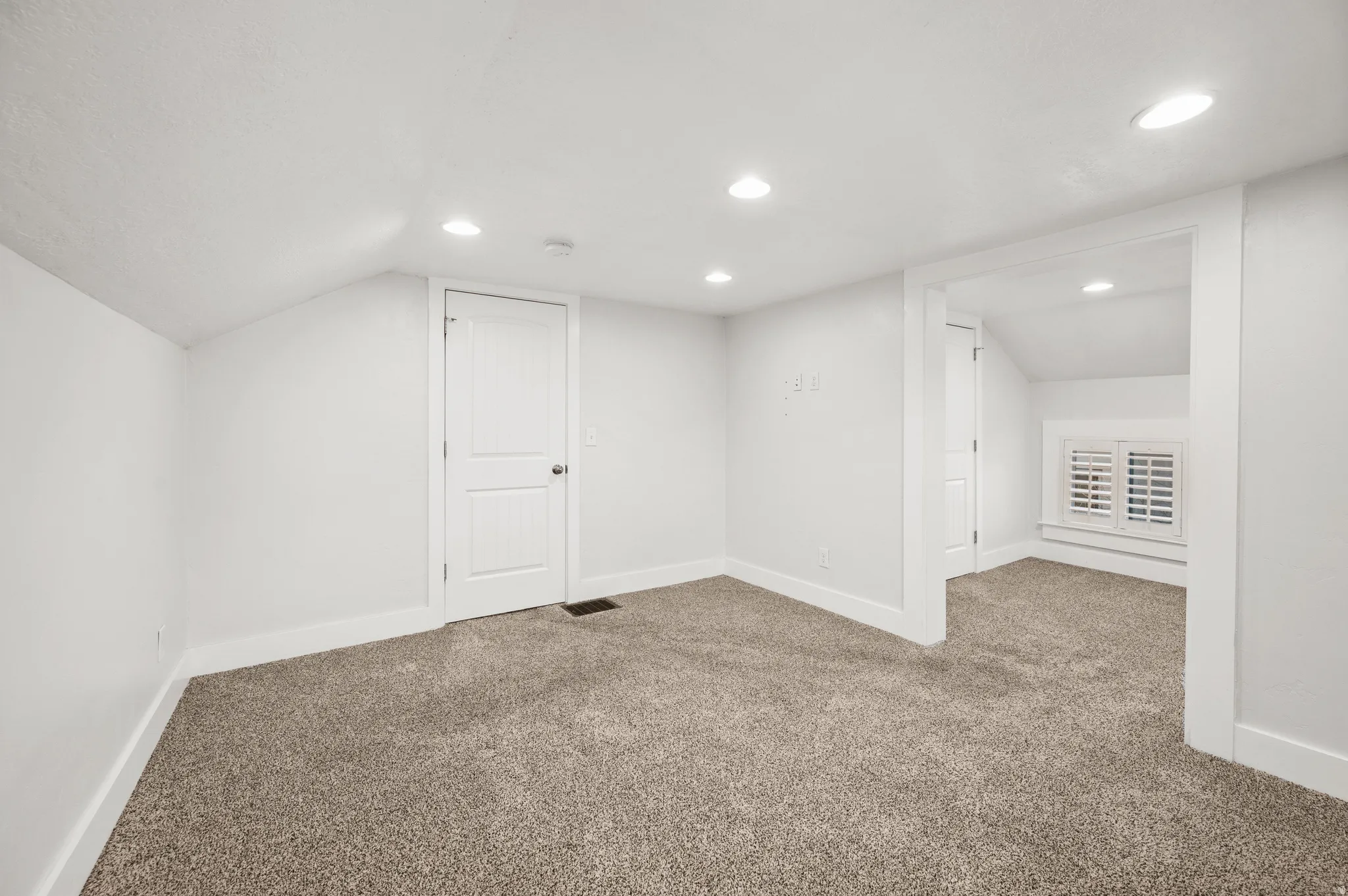 Additional living space with carpet flooring and recessed lighting