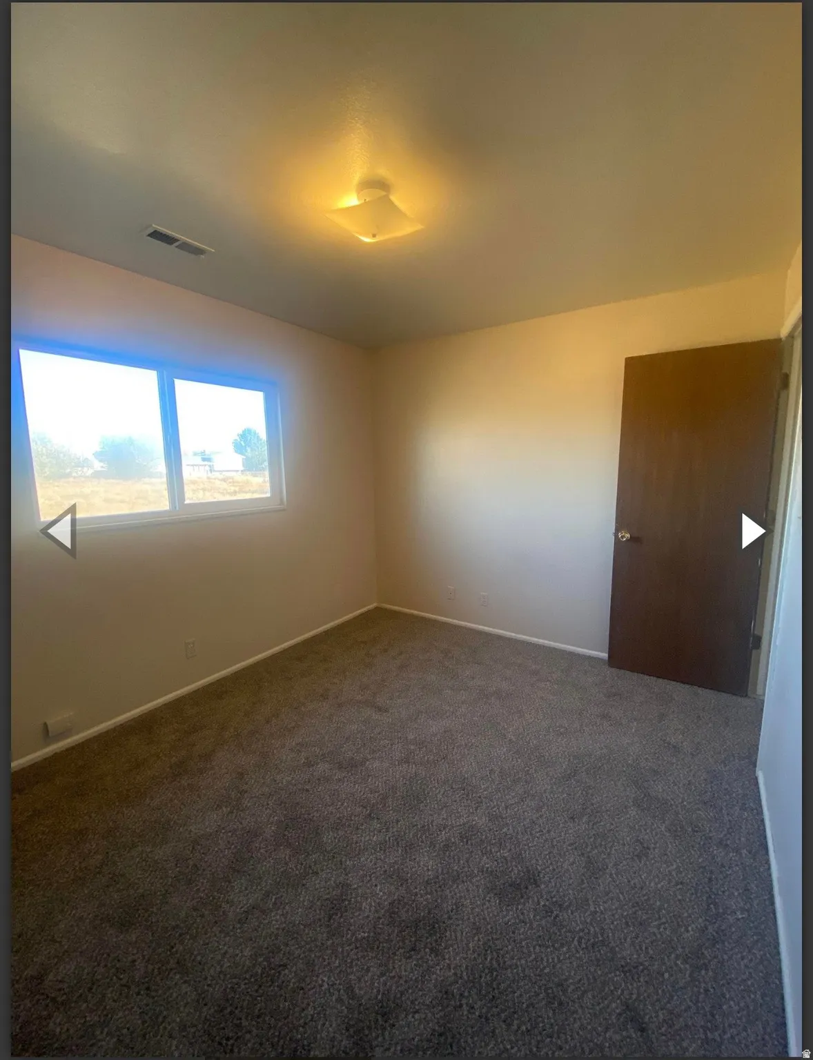 Carpeted empty room featuring baseboards