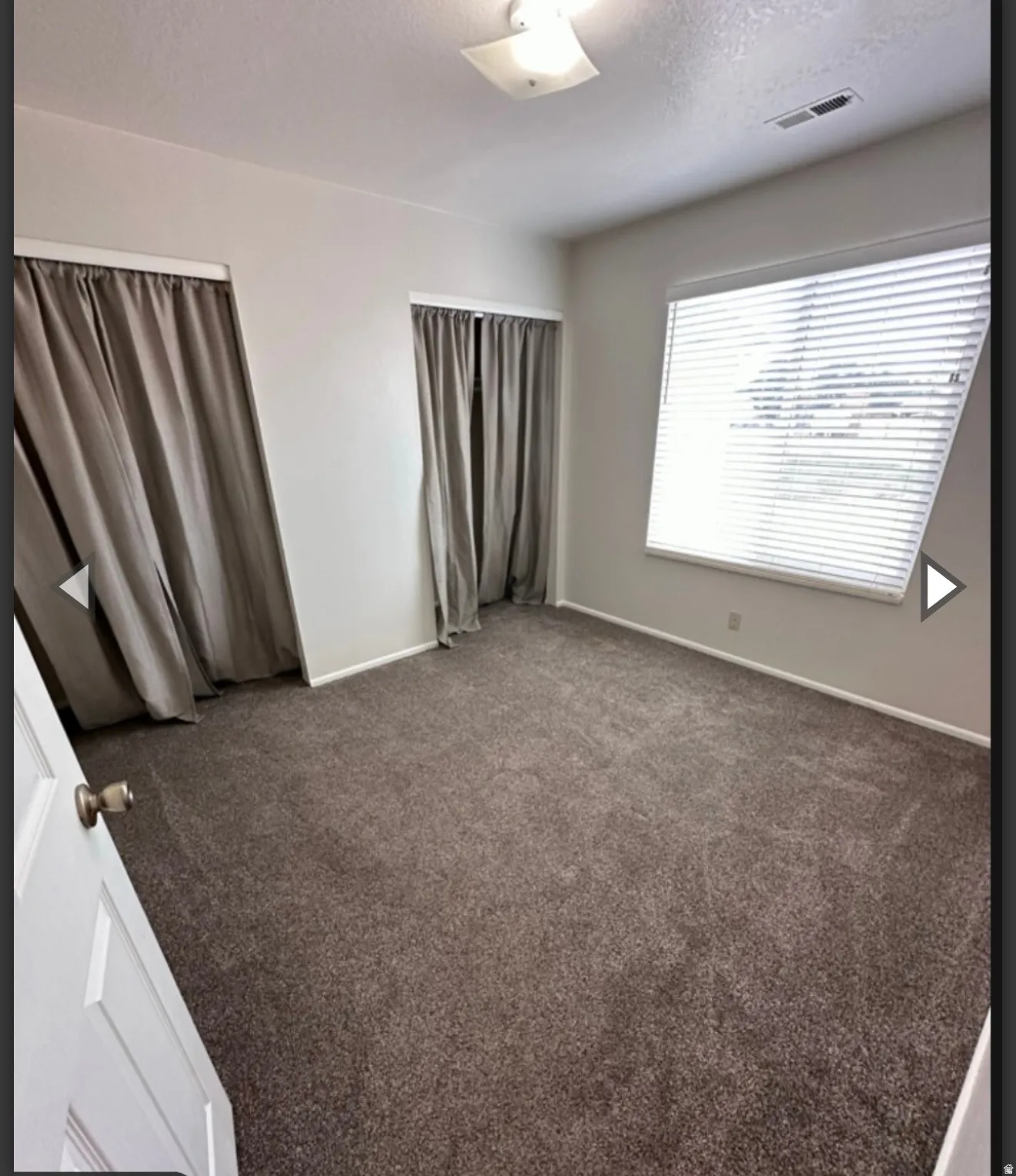 Unfurnished bedroom with a textured ceiling and carpet