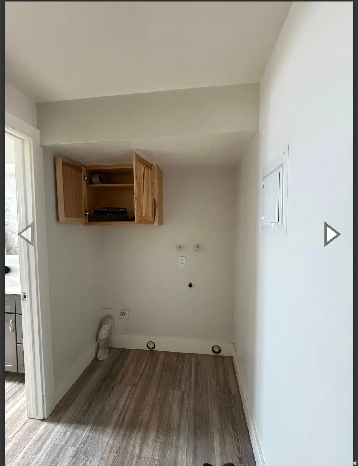 Laundry area featuring light wood-style floors, hookup for a washing machine, gas dryer hookup, and electric panel