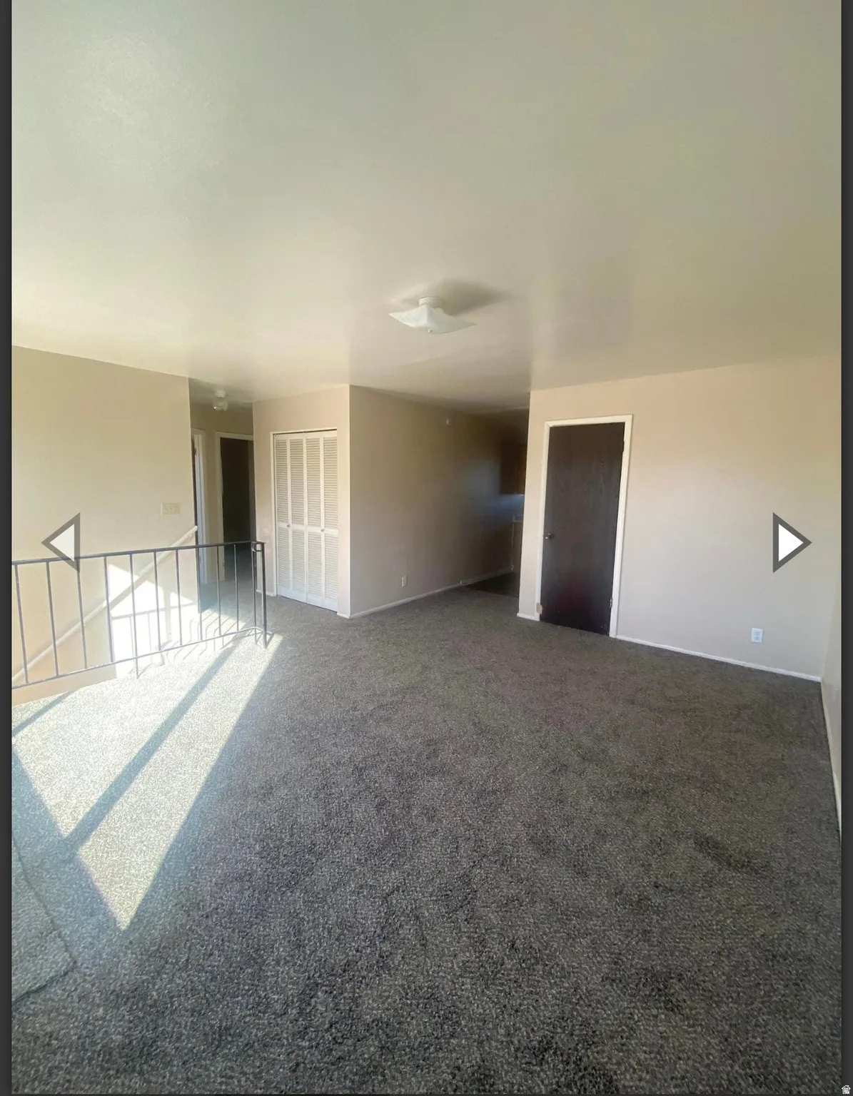 Carpeted spare room with baseboards